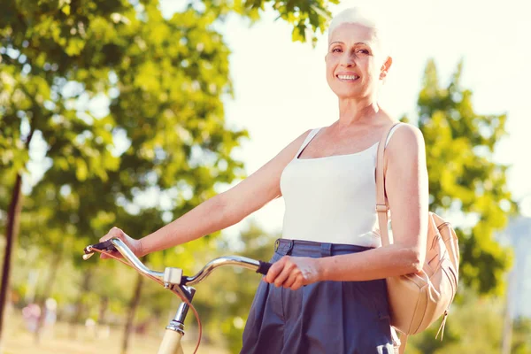 Neşeli yaşlı kadın parkta bisiklet — Stok fotoğraf
