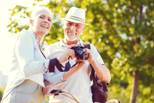 Extremadamente feliz pareja jubilada sonriendo después de la sesión de fotos familiar — Foto de Stock