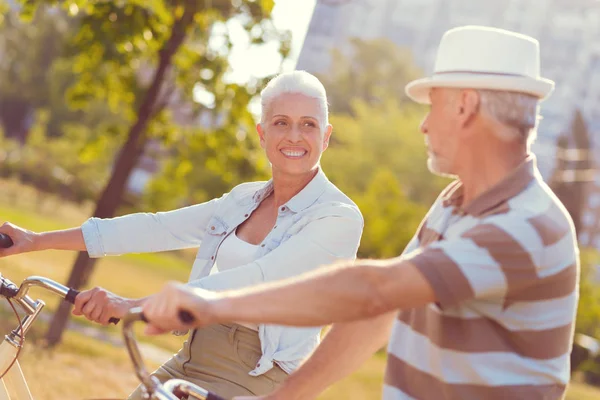 Fröhliches Paar mit Fahrrädern tratscht im Freien — Stockfoto