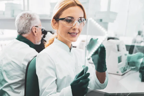 Química femenina usando anteojos escribiendo fórmula molecular — Foto de Stock