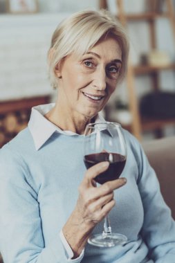 Şarap çeşnicibaşı. Kırmızı şarap tadımı sırasında yüzünde gülümseme tutmak güzel emeklilik