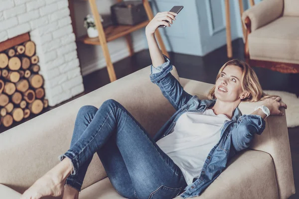 Relajada persona femenina acostada en un sofá acogedor — Foto de Stock