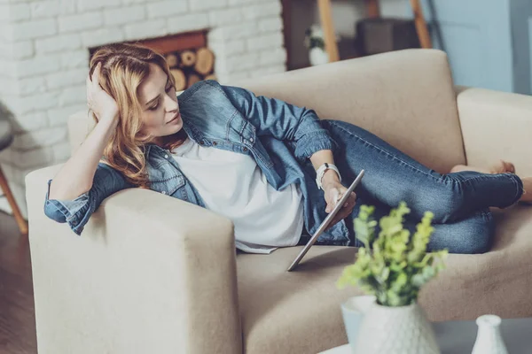 Jonge vrouwelijke persoon liggend op haar bank — Stockfoto