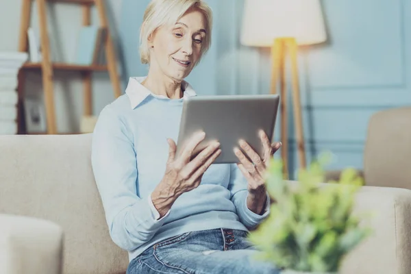 Positivo encantado persona femenina mirando su gadget — Foto de Stock