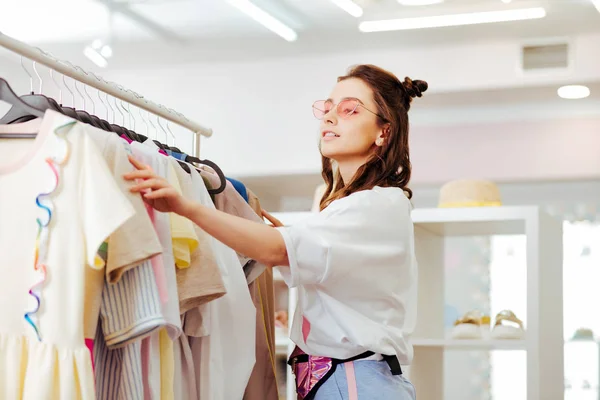 Donna moderna con bella acconciatura alla ricerca di nuovo vestito — Foto Stock