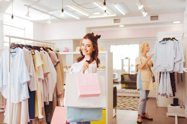 Dark-haired smiling woman holding many carton bags — Stock Photo, Image