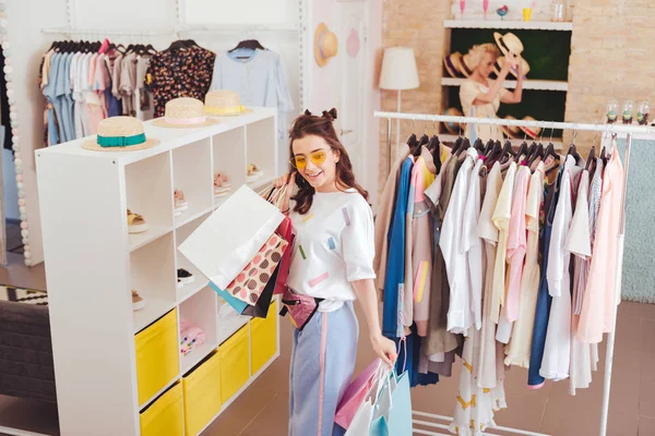 Stylischer Shopaholic steht neben Schuhständer im Showroom — Stockfoto