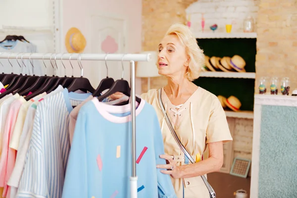 Blonďatá zralá žena stojící v nákupní centrum — Stock fotografie