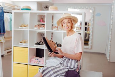 Emekli kadın ayakkabı dükkanında oturmuş şık şapka