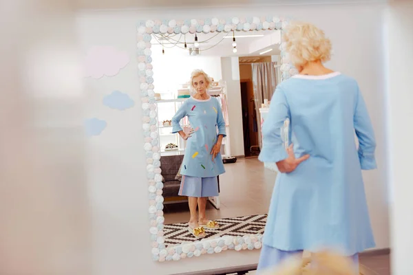 Loira de cabelos aposentados mulher tentando traje azul em — Fotografia de Stock