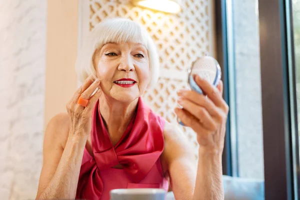 Alegre anciana tocándose la mejilla — Foto de Stock