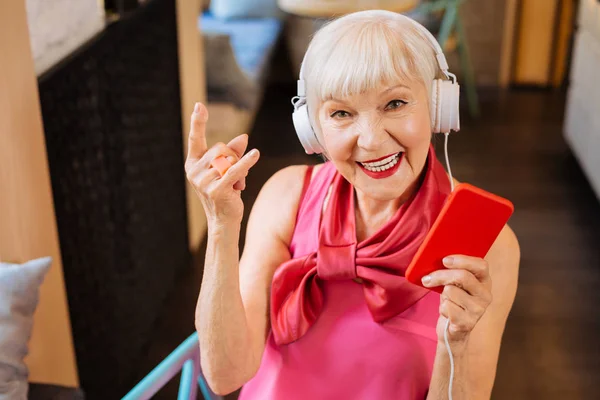 Счастливая старуха слушает рок-музыку — стоковое фото