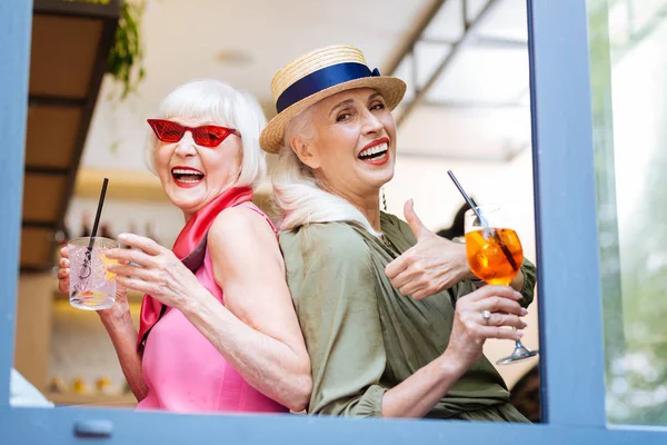 Mujeres con estilo positivo sosteniendo vasos con cócteles — Foto de Stock