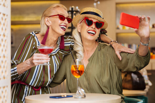 Радостные весёлые женщины фотографируют
