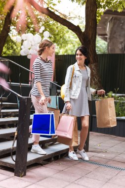 Kafeye gitmek alışveriş sonra beyaz spor ayakkabı giyen iki şık arkadaş