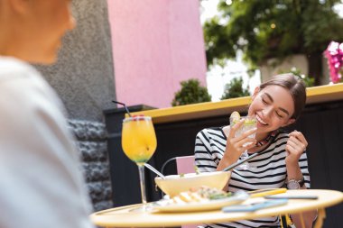 Mutlu kadın arkadaşı şakalar için dinlerken gülüyor