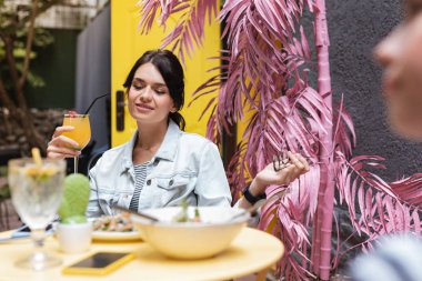 Terasta dinlendirici. Şık siyah saçlı kadın onun en iyi arkadaşı ile dekore edilmiş yaz terasında rahatlatıcı