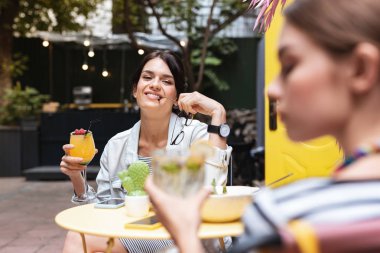 Gülümseyen ışınlama kadın gözlüklerini kafeteryada oturan holding