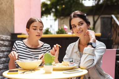 Patates kızartması yemek diyet izlerken arkadaş üzerinde oturan esmer kadın
