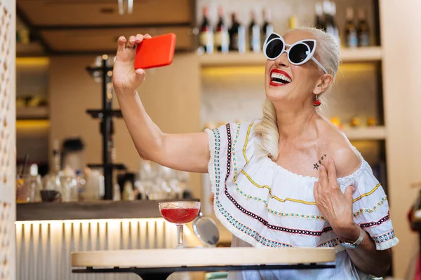 Delighted happy woman holding her smartphone — Stock Photo, Image