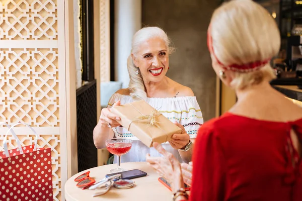 Vrolijke aangename vrouw met een geschenkdoos — Stockfoto