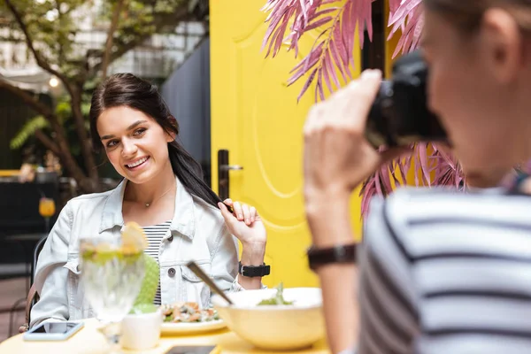 Módní usmívající se žena pózuje pro fotografie na letní terase — Stock fotografie