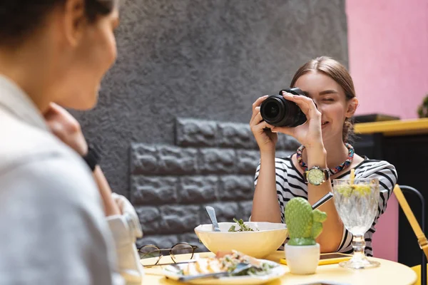 Fotógrafo disfrutando de su ocupación mientras toma una foto de un amigo — Foto de Stock