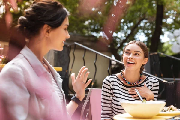 Две улыбающиеся успешные деловые женщины ведут захватывающий разговор — стоковое фото