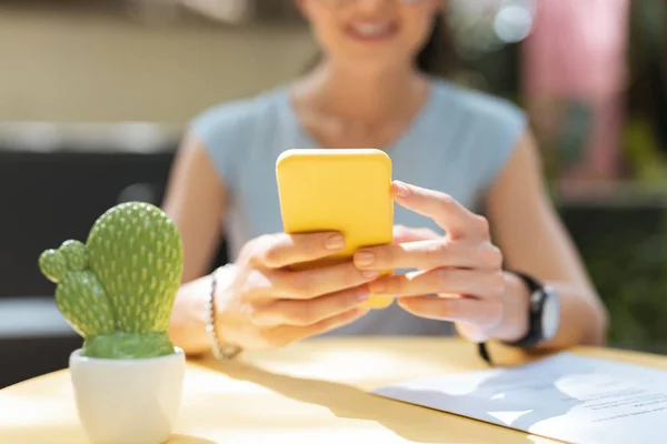 Ocupado freelancer revisando su correo electrónico en el teléfono inteligente amarillo —  Fotos de Stock