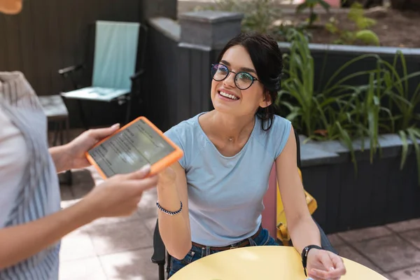 Mulher agradável bonita sorrindo enquanto conversa com garçonete — Fotografia de Stock