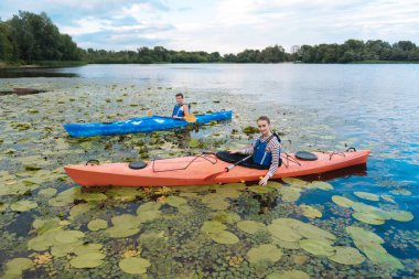 Genç adam ve kadın kayak yaparken birçok nilüferler fark