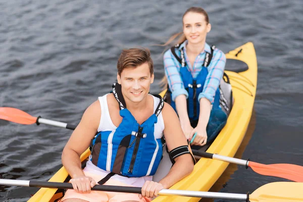 Bonito homem desfrutando de atividade esportiva enquanto remo em canoa — Fotografia de Stock