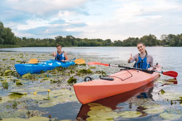 Lächelndes Paar zufrieden nach aktiver Flussfahrt im Kanu — Stockfoto