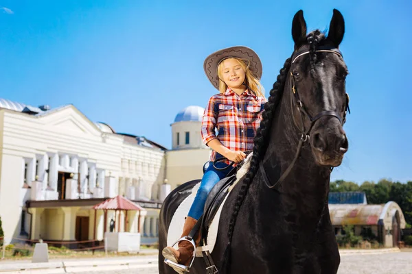 Blonde-Haired tizenéves lány lovaglás nemes fekete ló — Stock Fotó