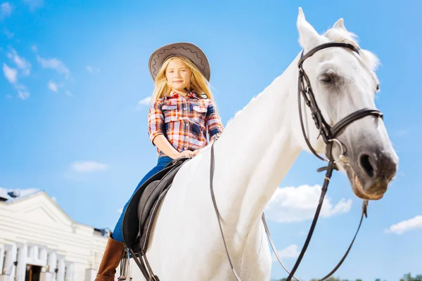 Beyaz yumuşak yarış atın üzerinde oturanbir şık kız öğrenci — Stok fotoğraf