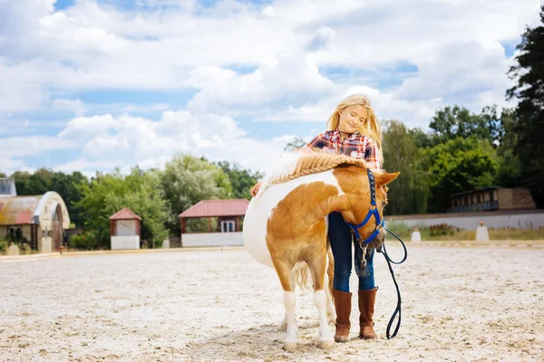 Belle fille aux cheveux blonds cow-boy debout près de poney mignon avec tresse — Photo