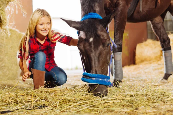 Beaming girl smiling broadly while visiting horse in stable — Stock Photo, Image