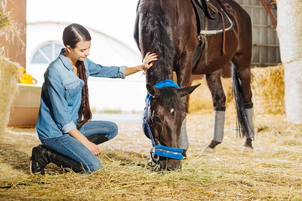 Σκούρα μαλλιά horsewoman με μακρά πλεξούδα που επισκέπτονται το σταθερό και το άλογο — Φωτογραφία Αρχείου