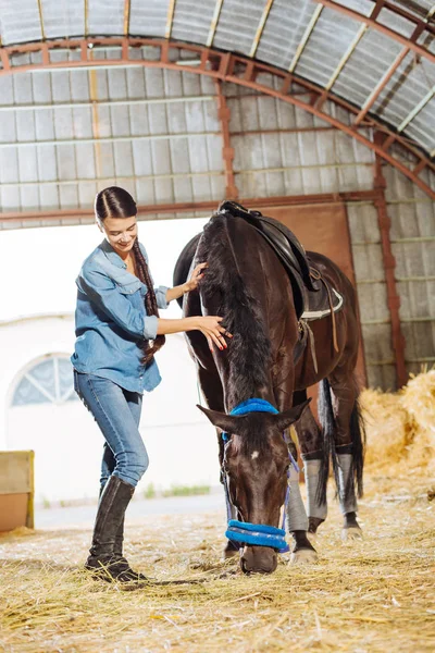 安定で彼女の馬の近くに立って笑顔かっこいい女性ライダー — ストック写真