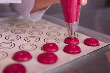 Küçük pembe macaroons pişirme parşömen kağıt üzerine şekillendirme Şef