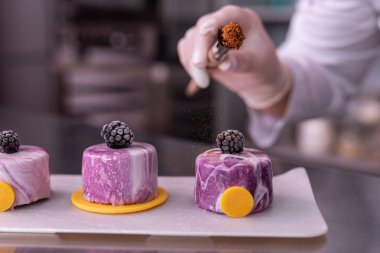 Ayna buzlanma ile pasta üzerinde bazı tarçın yağmurlama Baker