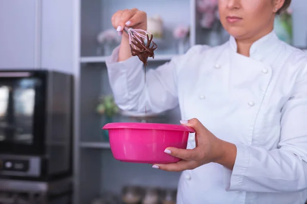 Vackra baker håller rosa skål med chokladmousse — Stockfoto