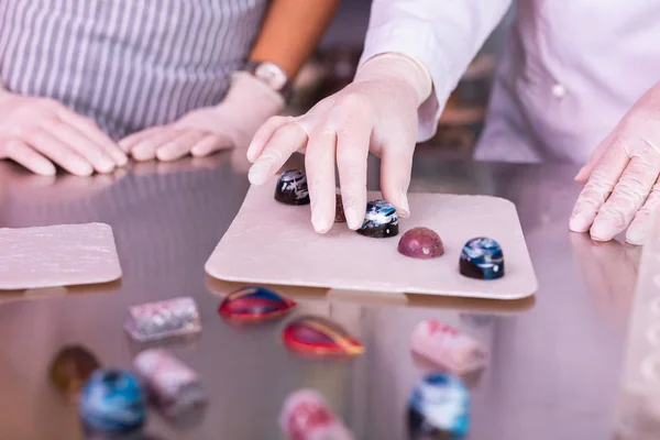 Zwei professionelle Köche mit weißen Handschuhen, die Süßigkeiten zubereiten — Stockfoto