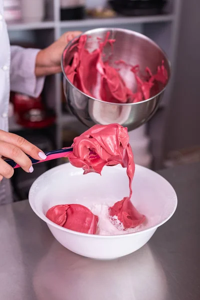 Confiseur mélangeant meringue rose et meringue blanche dans un grand bol — Photo