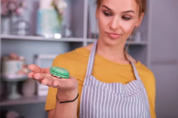 Suikergoed leerling kijken naar mooie kleine groene macaroon — Stockfoto