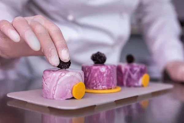 Professionelle Konditorin gibt Meisterkurs über das Dekorieren von Desserts — Stockfoto
