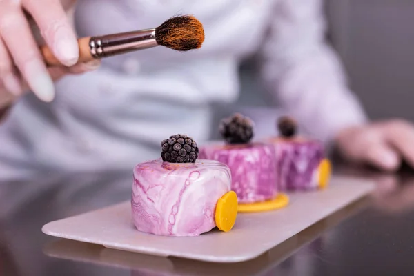 Kreative Bäckerin fühlt sich beim Dekorieren ihrer schönen Kuchen inspiriert — Stockfoto