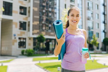 Mutlu genç kadın bir yoga mat