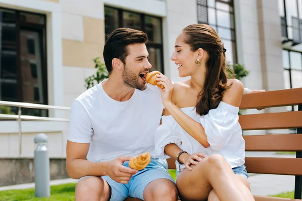 Delighted positive woman feeding her husband — Stock Photo, Image