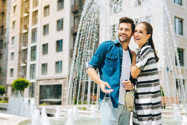 Deliziosa bella coppia in piedi vicino alla fontana — Foto Stock